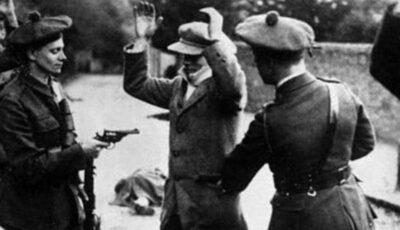 Des Black and Tans contrôlant un irlandais – Domaine public