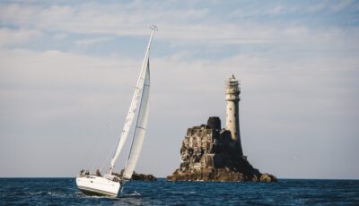 Un voilier aux abord du phare de Fastnet rock - © timursalikhov