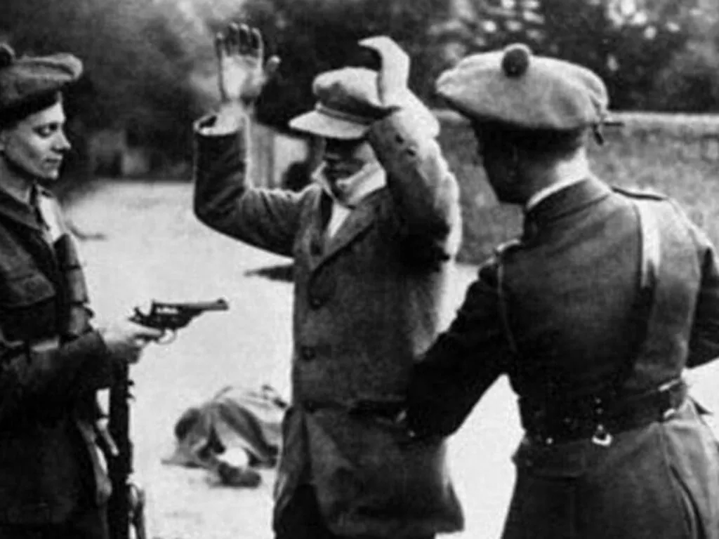 Des Black and Tans contrôlant un irlandais – Domaine public