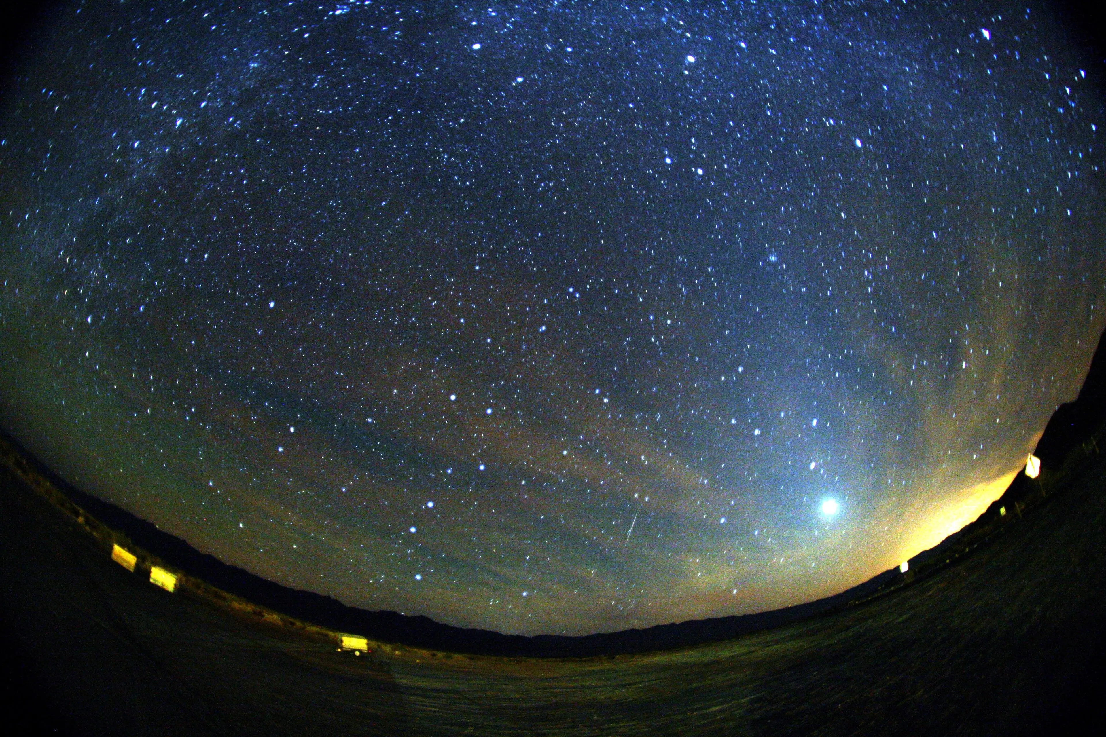 Trace lumineuse verte et rouge d’un météore des Orionides dans un ciel étoilé.